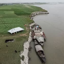 家の屋根を舟へ運ぶバングラデシュの人々（クリグラムのブラマプトラ川）