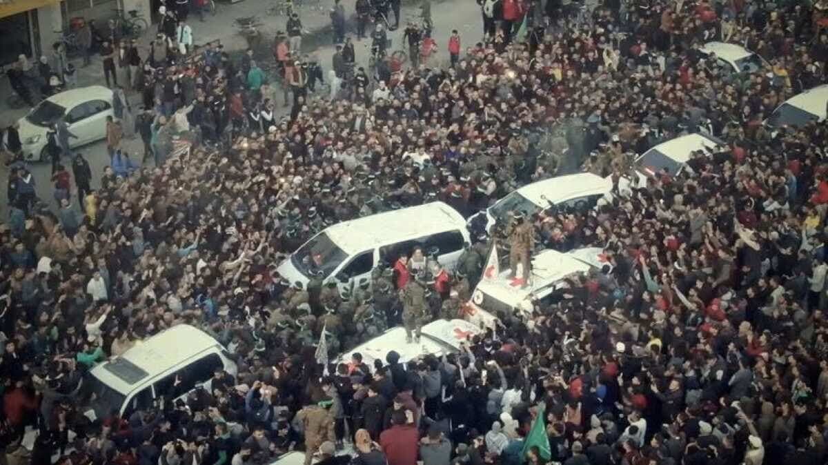 ガザ地区で人質が解放される中、車両の近くに集まる人々